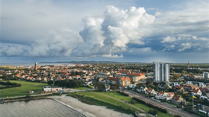 Bild på Höganäs tagen ovanifrån. Hus, himmel, hav och grönyta syns. 