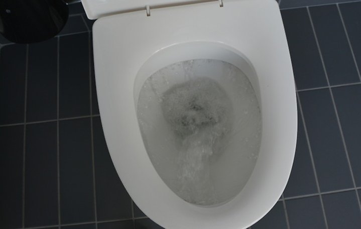 En toalett som spolar. Foto.
